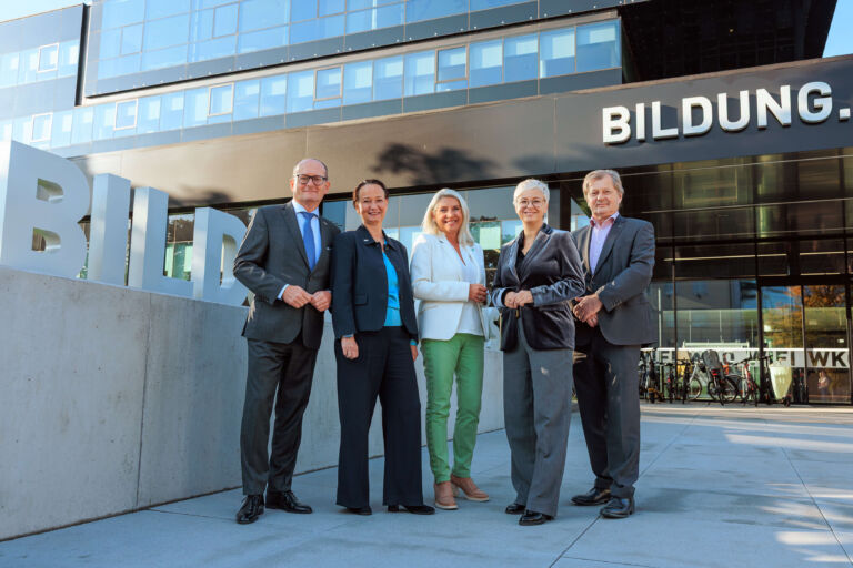 group of women and men standing in front of a building